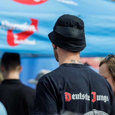 Ein junger Mann steht mit "Deutsche Jungs" T-Shirt auf einer AfD Wahlveranstaltung