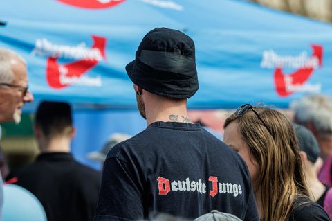 Ein junger Mann steht mit "Deutsche Jungs" T-Shirt auf einer AfD Wahlveranstaltung