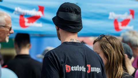 Ein junger Mann steht mit "Deutsche Jungs" T-Shirt auf einer AfD Wahlveranstaltung