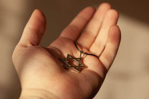 Ein Davidstern-Anhänger liegt in einer geöffneten Hand