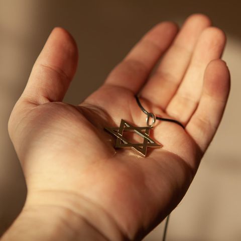 Ein Davidstern-Anhänger liegt in einer geöffneten Hand