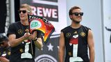 Letztes Spiel: Kroos und Siegtorschütze Mario Götze mit Sonnenbrillen: Mit dem Weltmeister-Pokal im Gepäck feiert die deutsche Nationalmannschaft mit den Fans in Berlin Kroos und Siegtorschütze Mario Götze mit Sonnenbrillen: Mit dem Weltmeister-Pokal im Gepäck feiert die deutsche Nationalmannschaft mit den Fans in Berlin