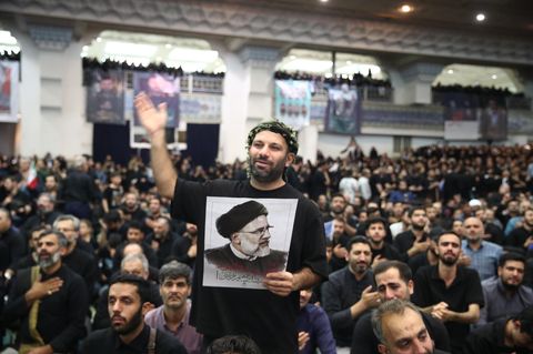 Trauerfeier in Teheran: Teilnehmer halten Plakate des verunglückten Präsidenten Ebrahim Raisi