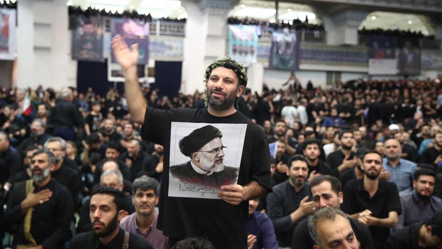 Trauerfeier in Teheran: Teilnehmer halten Plakate des verletzten Präsidenten Ebrahim Raisi in der Hand