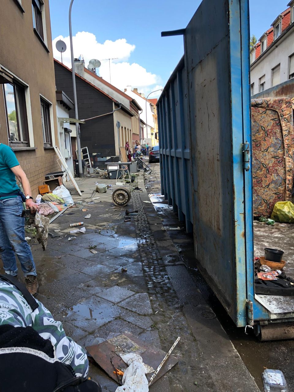 In einer Gasse liegen überall von dem Hochwasser vertreute Gegenstände. Vieles ist für immer unbrauchbar.