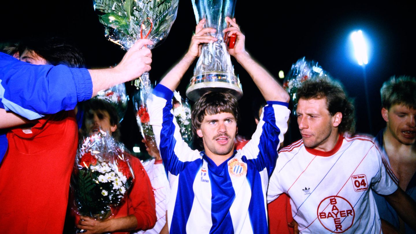 Nach der Siegerehrung trägt Torschütze Falko Götz den Pokal als Krone, daneben ist Kapitän Wolfgang Rolf zu sehen.