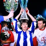 Nach der Siegerehrung trägt Torschütze Falko Götz den Pokal als Krone, daneben ist Kapitän Wolfgang Rolf zu sehen.