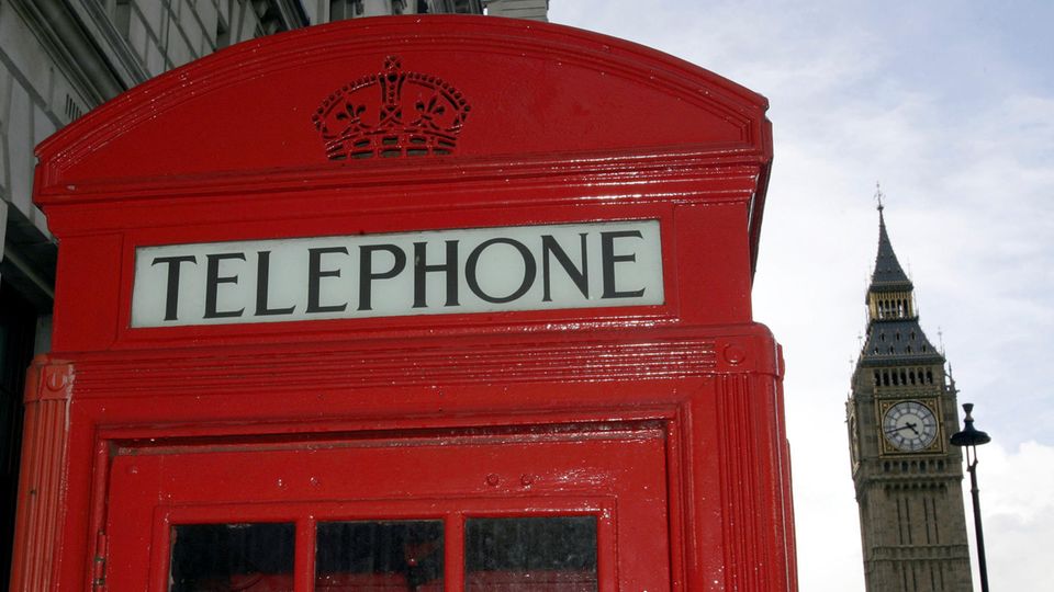 Eine rote Telefonzelle steht vor dem Big Ben in London