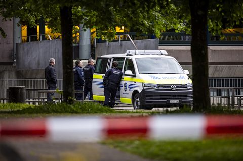 Polizisten stehen neben ihrem Einsatzwagen in der Schweiz