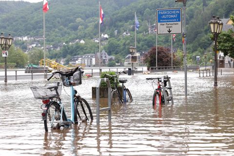 Fahrräder stehen im Wasser auf der überfluteten Promenade an der Mosel