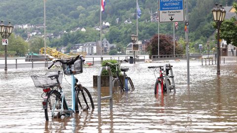 Fahrräder stehen im Wasser auf der überfluteten Promenade an der Mosel