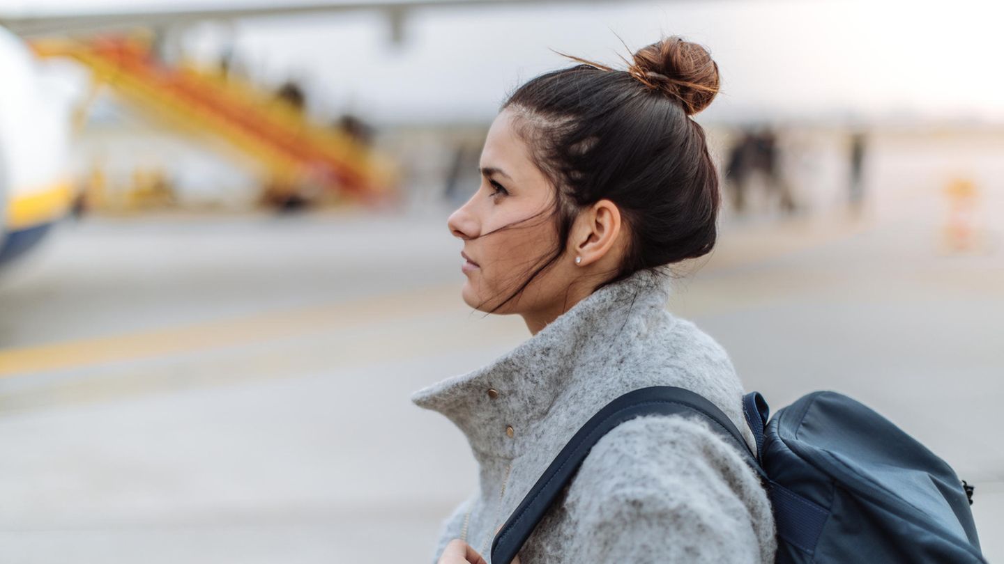 Ernste Frau steht auf dem Rollfeld in der Nähe von Flugzeugen Ernste Frau steht auf dem Rollfeld in der Nähe von Flugzeugen