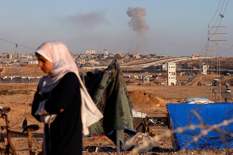Eine Frau geht nach einem israelischen Luftangriff an der Stadt Rafah vorbei