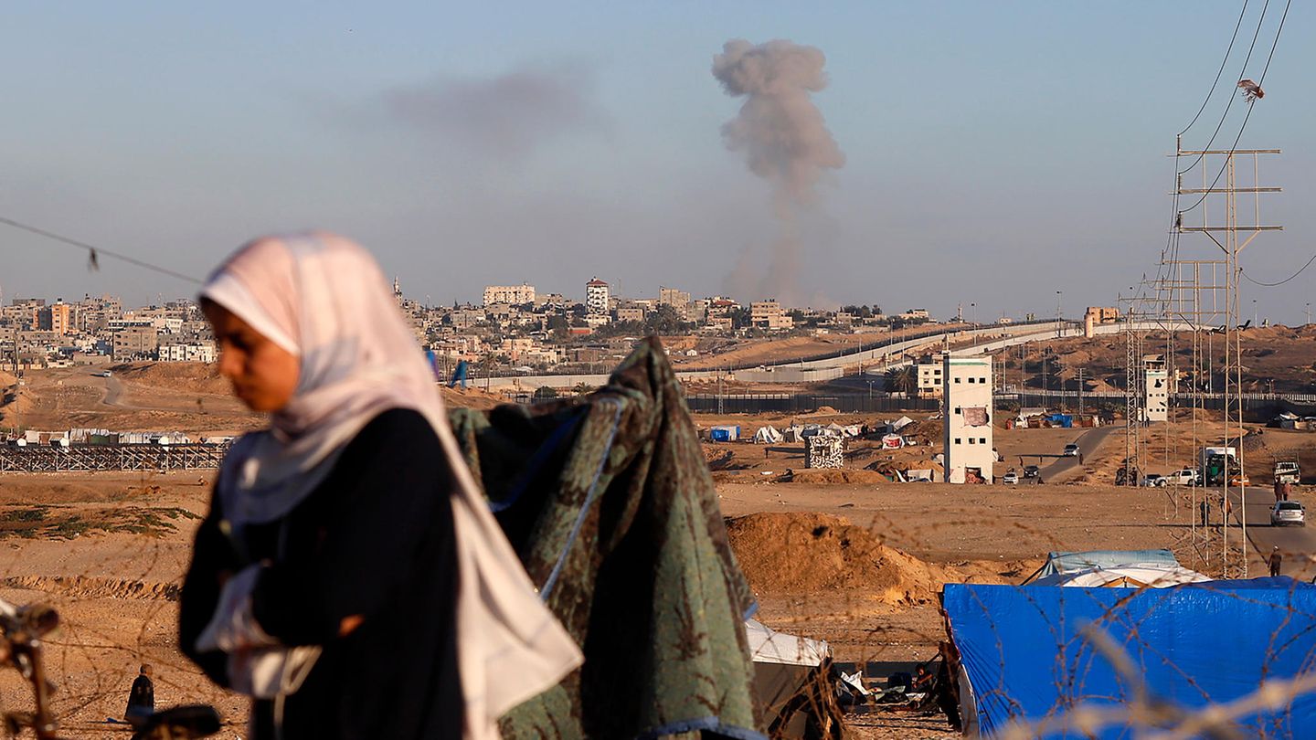 Eine Frau geht nach einem israelischen Luftangriff an der Stadt Rafah vorbei.