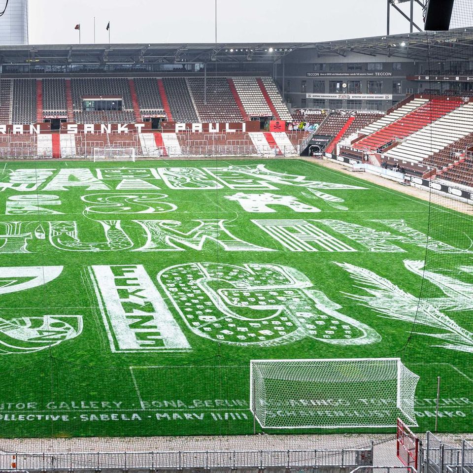 Hamburg, Deutschland. Verschiedene Künstler haben den Rasen des Millerntor-Stadions auf St. Pauli mit dem Schriftzug "Water Is A Human Right" versehen. Jeder Buchstabe wurde dabei anders gestaltet. Es ist allerdings nur ein flüchtiges Kunstwerk. Im Laufe des Tages verschwindet es wieder, weil der Klub einen neuen Rasen ausrollt.         