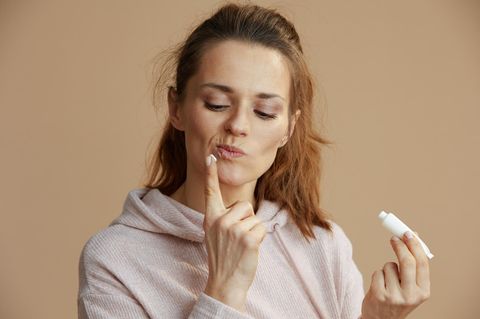 Frau behandelt ihr Lippenherpes