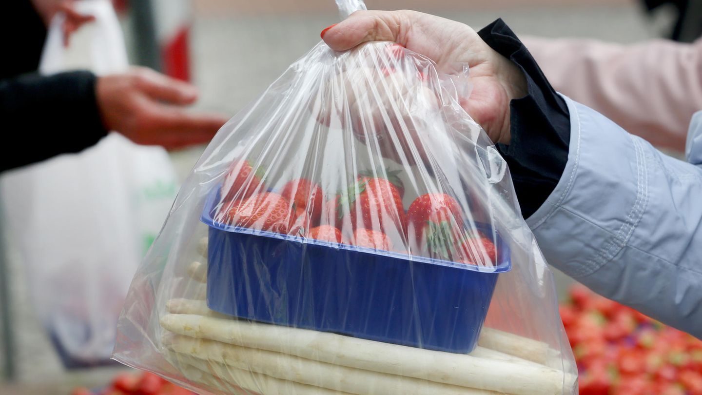 Am Verkaufsstand sind verpackter Spargel und Erdbeeren verteilt.