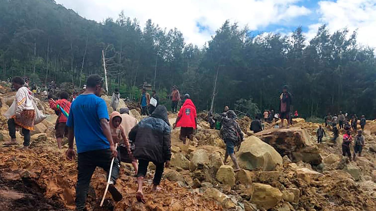 Menschen klettern über den Erdrutsch in Papua Neuguinea