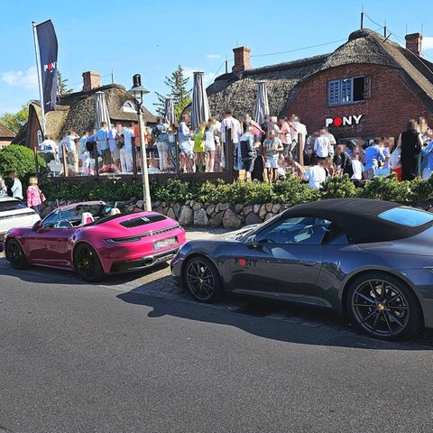 Teure Autos stehen vor dem Außenbereich der "Pony"-Bar im Ort Kampen, Sylt