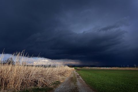 Gewitterwolken ziehen über ein Feld. Auch heute brauen sich über einigen Teilen Deutschlands wieder Unwetter zusammen.