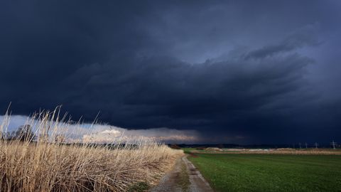 Gewitterwolken ziehen über ein Feld. Auch heute brauen sich über einigen Teilen Deutschlands wieder Unwetter zusammen.