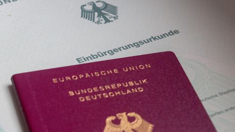 Israelis: Eine Einbürgerungsurkunde der Bundesrepublik Deutschland und ein deutscher Reisepass liegen auf einem Tisch