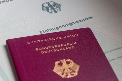 Israelis: Eine Einbürgerungsurkunde der Bundesrepublik Deutschland und ein deutscher Reisepass liegen auf einem Tisch