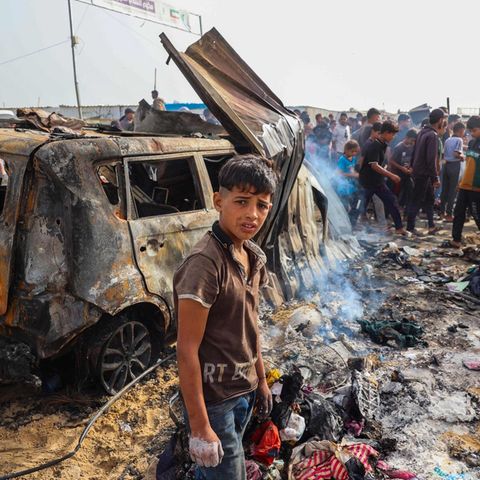 Ein palästinensischer Junge vor einem ausgebrannten Auto in Rafah nach dem Angriff der israelischen Luftwaffe