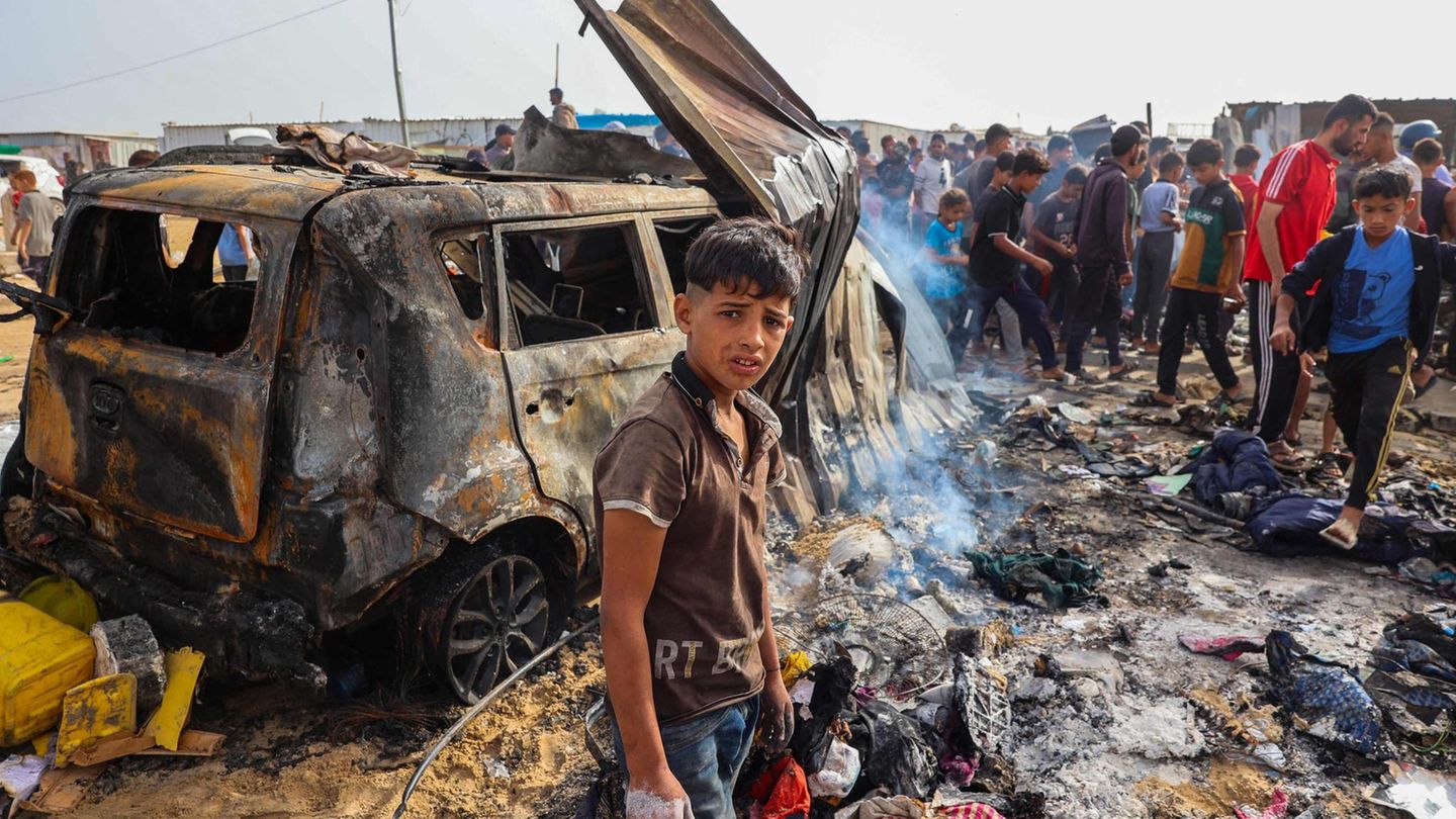 Luftangriff auf Rafah: Tod, Flammen, Zerstörung: Ein palästinensischer Junge vor einem ausgebrannten Auto in Rafah, nach dem Angriff der israelischen Luftwaffe. Ein palästinensischer Junge vor einem ausgebrannten Auto in Rafah nach dem Angriff der israelischen Luftwaffe