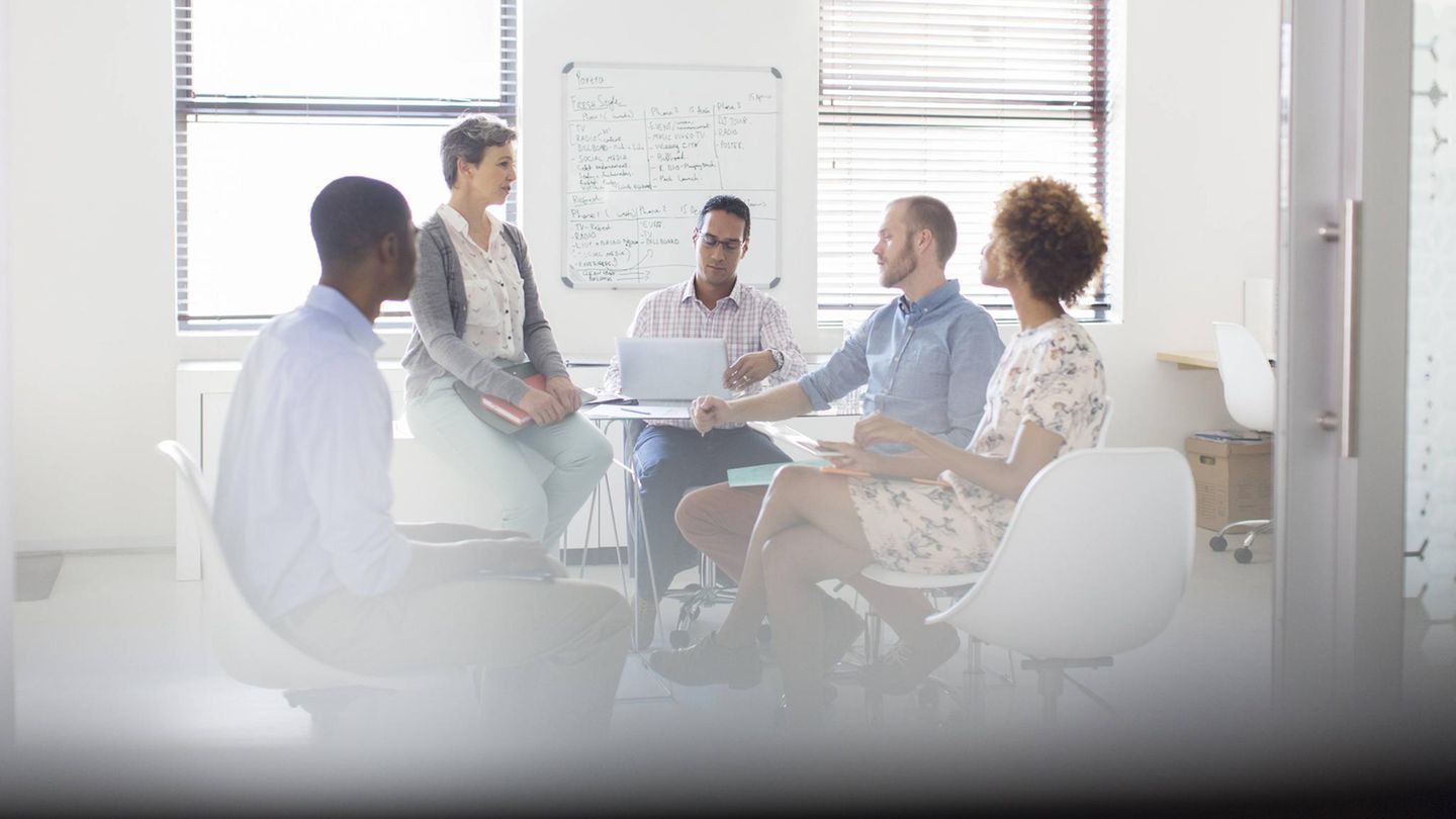 Zwei Frauen und drei Männer bei einem Meeting im Büro