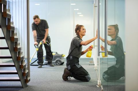 Eine männliche und eine weibliche Reinigungskraft bei der Arbeit