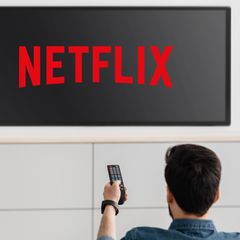Ein Mann schaltet einen Fernseher ein, der das Netflix-Logo zeigt