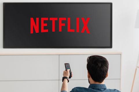 Ein Mann schaltet einen Fernseher ein, der das Netflix-Logo zeigt
