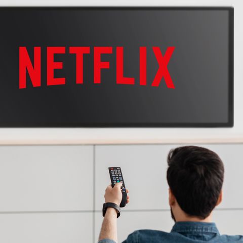 Ein Mann schaltet einen Fernseher ein, der das Netflix-Logo zeigt