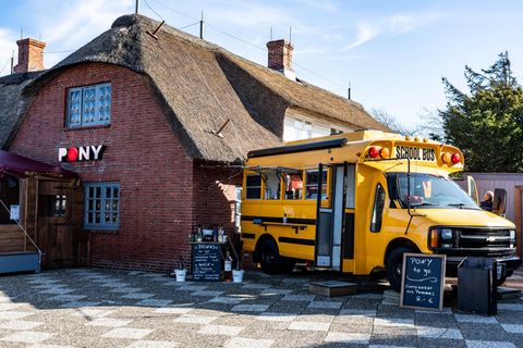 Ein alter amerikanischer Schulbus steht als Ausschank neben der Gaststätte ·Pony