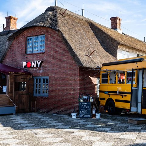 Ein alter amerikanischer Schulbus steht als Ausschank neben der Gaststätte ·Pony