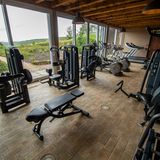 Wer nicht genug vom Training bekommt, kann im Fitnessraum mit Blick auf die grüne Hügellandschaft weiter schwitzen.