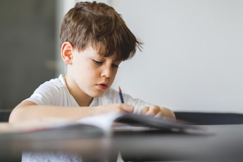 Symbolbild Bericht einer Lehrerin: Ein Junge sitzt zuhause an einem Schreibtisch und lernt