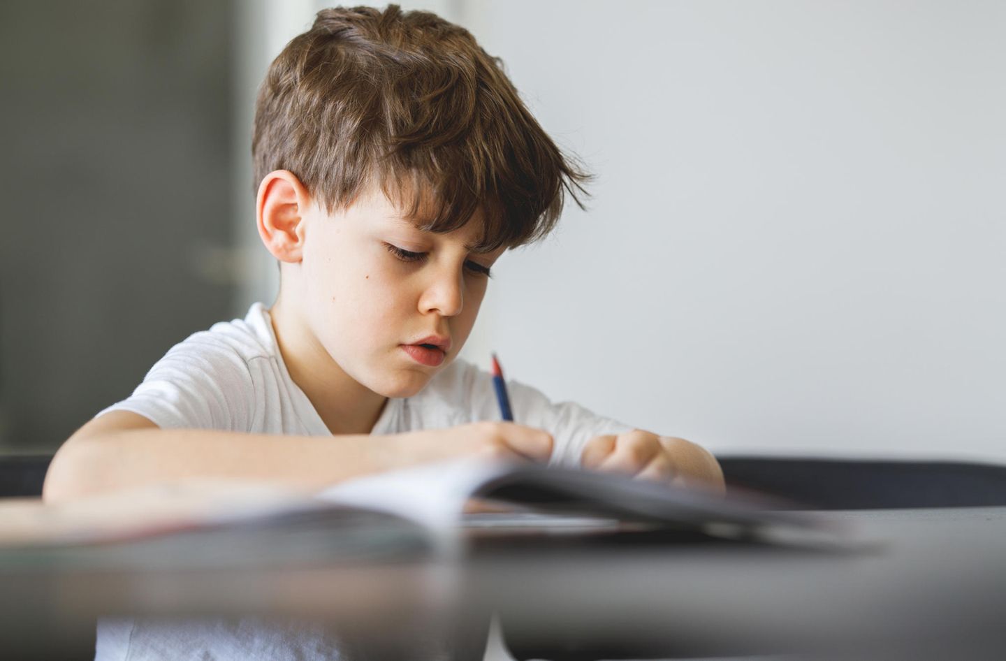 Symbolbild Bericht einer Lehrerin: Ein Junge sitzt zuhause an einem Schreibtisch und lernt