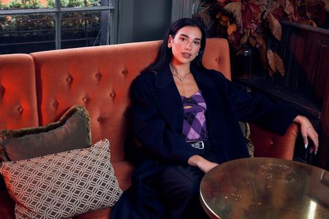 Dua Lipa auf der Couch in die Kamera blickend