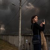 Eine junge Frau fotografiert mit ihrem Handy den Großbrand des Epicenter Einkaufszentrum