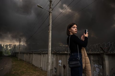 Eine junge Frau fotografiert mit ihrem Handy den Großbrand des Epicenter Einkaufszentrum