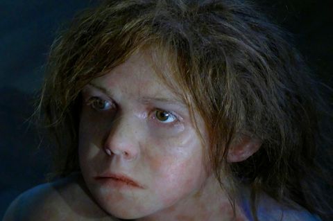 Portrait eines Neandertaler-Jungen mit langen braunen Haaren (Rekonstruktion)
