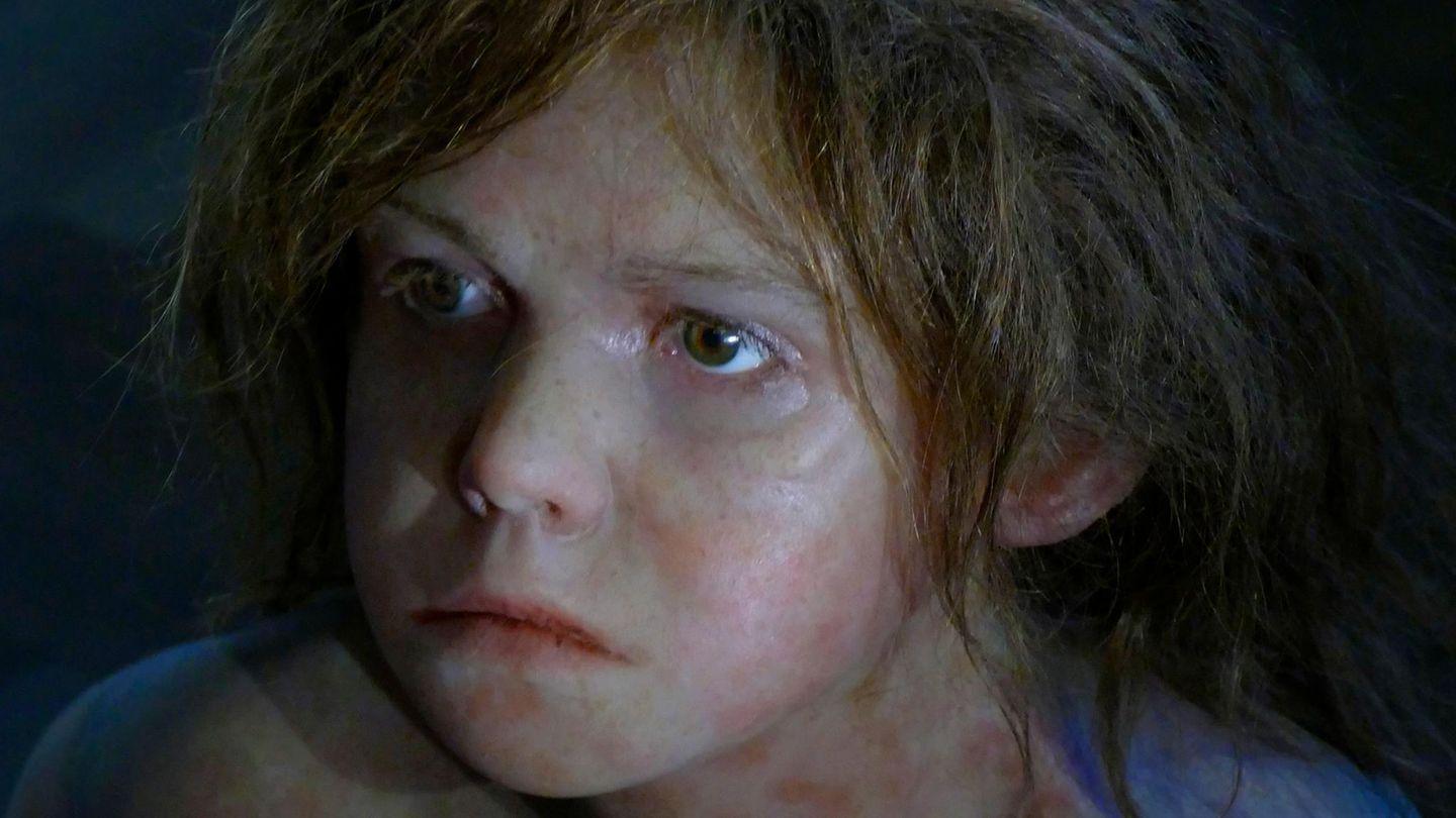 Portrait eines Neandertaler-Jungen mit langen braunen Haaren (Rekonstruktion)