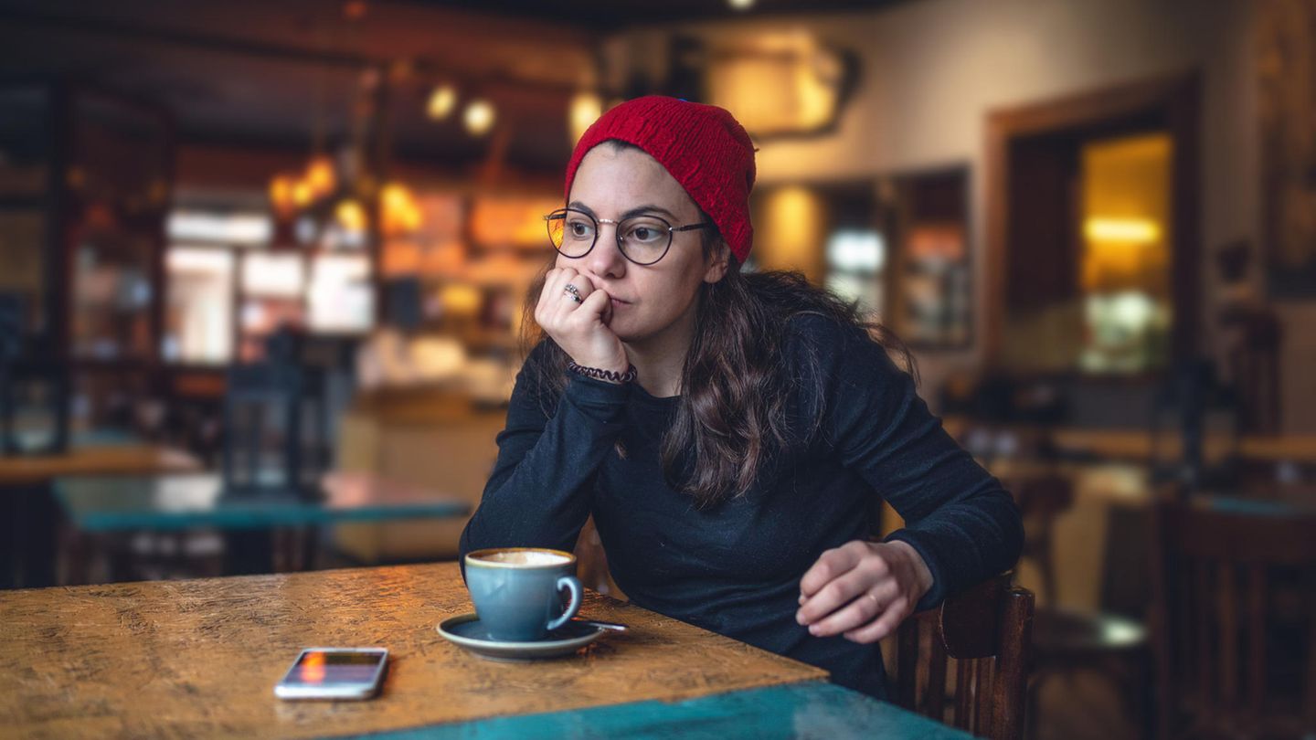 Einsame Frau sitzt nachdenklich im Café