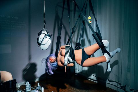 Eine leicht bekleidete Sexpuppe hängt in Seilen