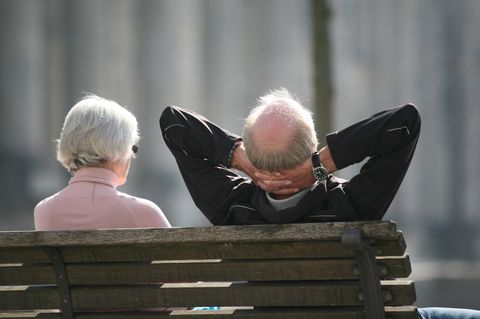 Ein älteres Paar sitzt entspannt auf der Bank in der Sonne (Symbolbild Lebenserwartung)