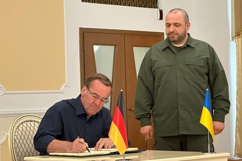 Boris Pistorius (SPD) trägt sich in Anwesenheit seines Amtskollegen Rustem Umjerow (r), aus der Ukraine, ins Gästebuch ein