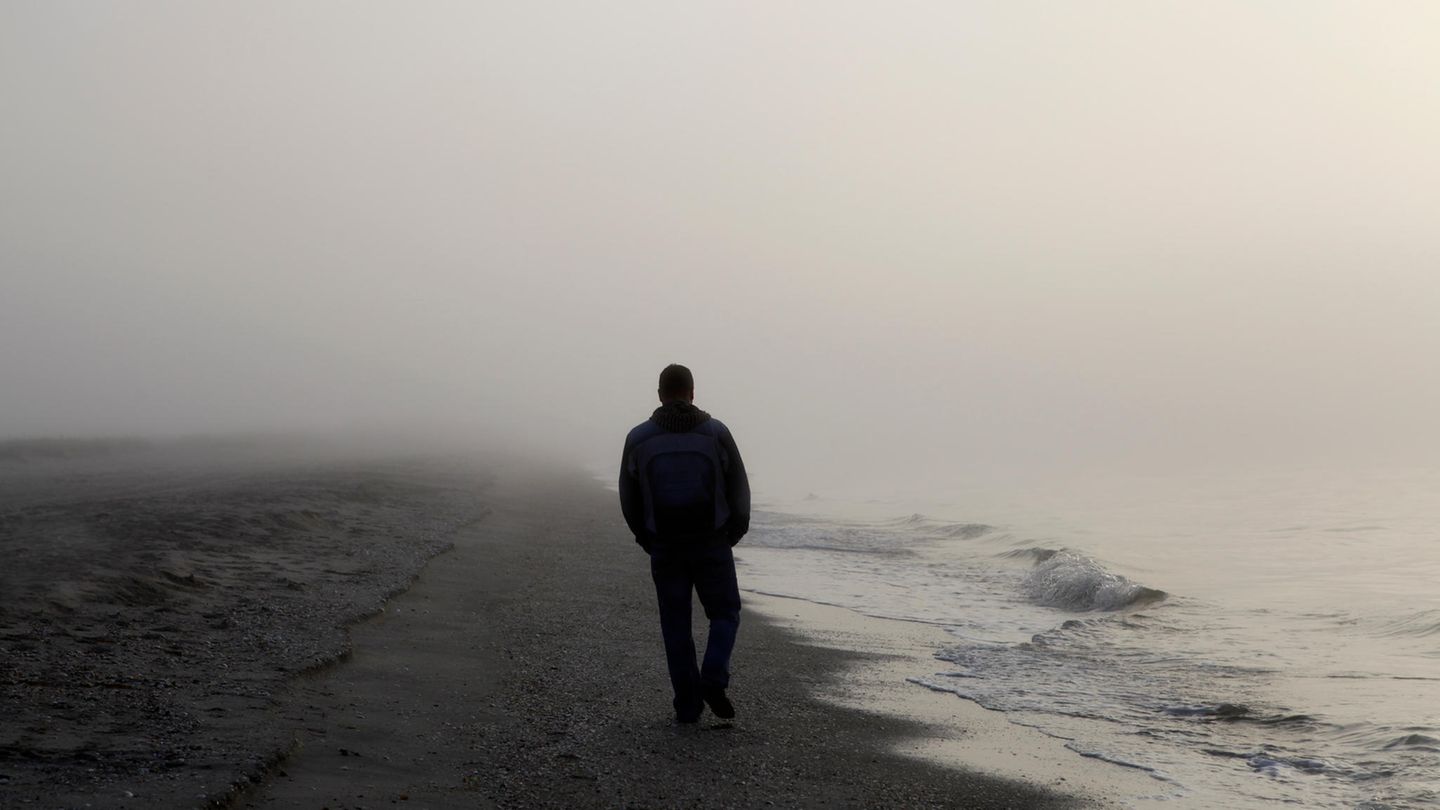 Depression bei Männern: Ein Mann geht einsam am Strand spazieren Depression bei Männern: Ein Mann geht einsam am Strand spazieren
