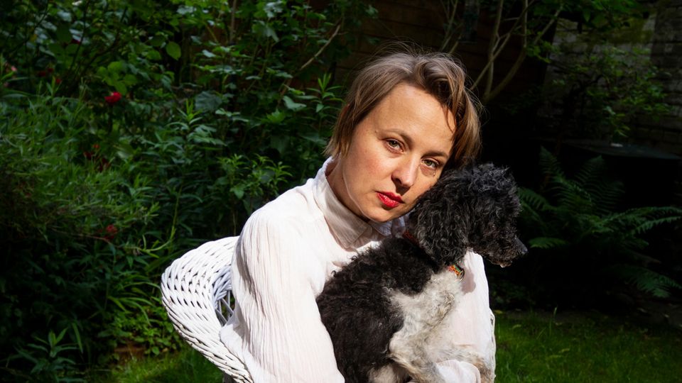 Portrait der Schauspielerin Katja Danowski in ihrem Garten mit Hund Frido